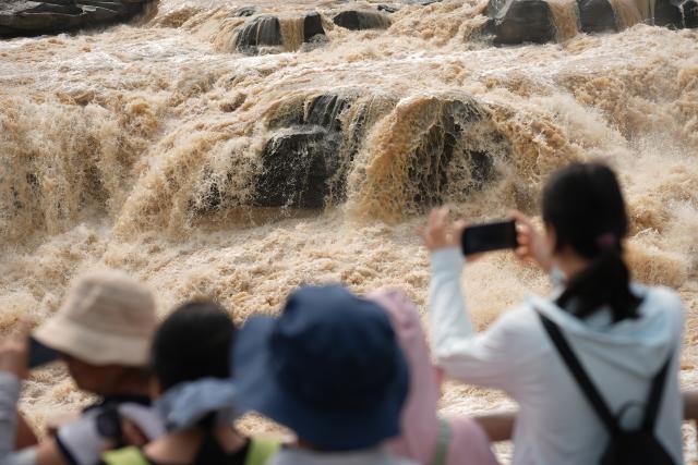 (260811) -- XI'AN, Aug. 11, 2026 (Xinhua) -- Tourists visit the Yellow River's Hukou Waterfall in northwest China's Shaanxi Province, Aug. 10, 2026. (Xinhua/Shao Rui)