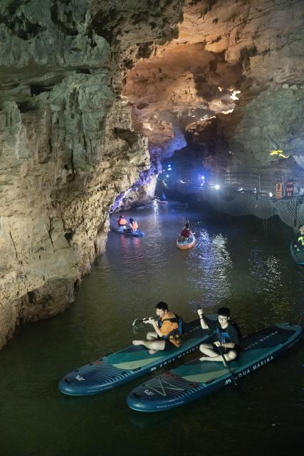 (260811) -- GUIYANG, Aug. 11, 2026 (Xinhua) -- Tourists enjoy paddleboarding inside a karst cave in Suiyang County, southwest China's Guizhou Province, Aug. 6, 2026. Best known for its karst landscape, Guizhou has made the best of karst caves to develop distinctive sites for cooling retreats. Featuring natural geological wonders, cooling enjoyment and water amusements, this emerging tourist experience has become a hit among locals and visitors alike. (Photo by Li Qianyong/Xinhua)