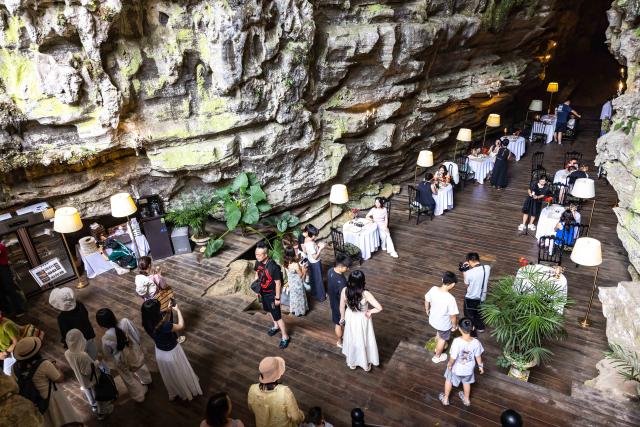 (260811) -- GUIYANG, Aug. 11, 2026 (Xinhua) -- Tourists visit a cafe inside a karst cave in Anshun City, southwest China's Guizhou Province, Aug. 8, 2026. Best known for its karst landscape, Guizhou has made the best of karst caves to develop distinctive sites for cooling retreats. Featuring natural geological wonders, cooling enjoyment and water amusements, this emerging tourist experience has become a hit among locals and visitors alike. (Photo by Chen Xi/Xinhua)