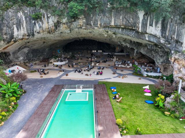 (260811) -- GUIYANG, Aug. 11, 2026 (Xinhua) -- A drone photo taken on Aug. 10, 2026 shows tourists enjoying themselves at a cafe inside a karst cave in Xiuwen County of Guiyang City, southwest China's Guizhou Province. Best known for its karst landscape, Guizhou has made the best of karst caves to develop distinctive sites for cooling retreats. Featuring natural geological wonders, cooling enjoyment and water amusements, this emerging tourist experience has become a hit among locals and visitors alike. (Photo by Yuan Fuhong/Xinhua)