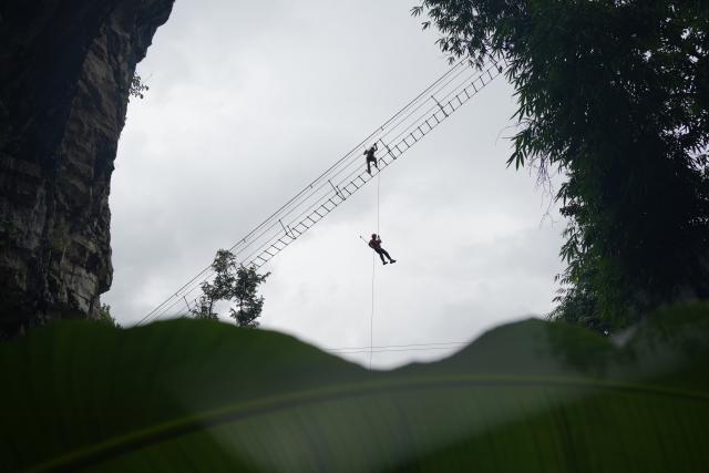 (260811) -- GUIYANG, Aug. 11, 2026 (Xinhua) -- Tourists enjoy via ferrata climb at a karst cave in Zunyi City, southwest China's Guizhou Province, Aug. 7, 2026. Best known for its karst landscape, Guizhou has made the best of karst caves to develop distinctive sites for cooling retreats. Featuring natural geological wonders, cooling enjoyment and water amusements, this emerging tourist experience has become a hit among locals and visitors alike. (Photo by Zhang Zhengju/Xinhua)