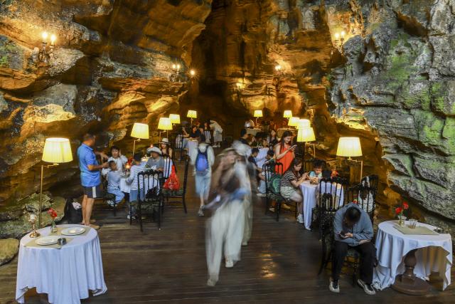 (260811) -- GUIYANG, Aug. 11, 2026 (Xinhua) -- Tourists visit a cafe inside a karst cave in Anshun City, southwest China's Guizhou Province, Aug. 6, 2026. Best known for its karst landscape, Guizhou has made the best of karst caves to develop distinctive sites for cooling retreats. Featuring natural geological wonders, cooling enjoyment and water amusements, this emerging tourist experience has become a hit among locals and visitors alike. (Photo by Lu Wei/Xinhua)