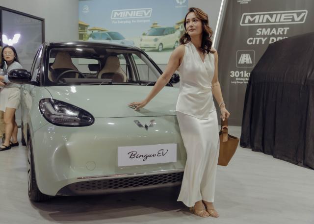 (260811) -- KATHMANDU, Aug. 11, 2026 (Xinhua) -- A woman poses in front of a Wuling Binguo EV showcased during the NAIMA Nepal Mobility Expo 2026 in Kathmandu, Nepal, Aug. 11, 2026. An auto show featuring over 50 automobile brands from various countries kicked off in Nepal's capital Kathmandu on Tuesday, showcasing new vehicles and mobility technologies to visitors. (Photo by Sulav Shrestha/Xinhua)