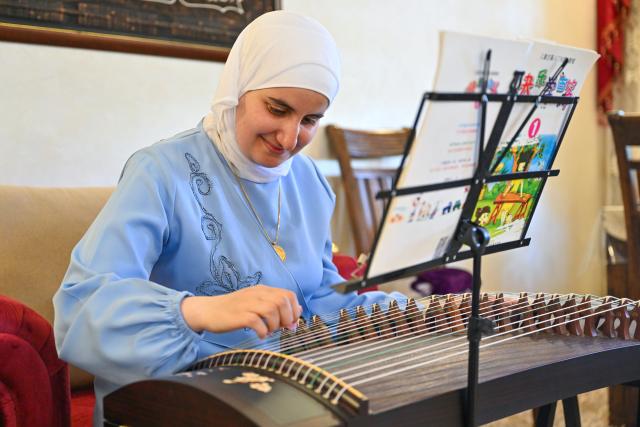 (260812) -- AMMAN, Aug. 12, 2026 (Xinhua) -- Manal Al-Khammash plays Guzheng, a Chinese traditional musical instrument, at her home in Amman, Jordan, July 20, 2026. TO GO WITH "Feature: From Amman to Beijing: Young sinologist builds a literary bridge between Arab and Chinese cultures" (Xinhua/Xin Mengchen)