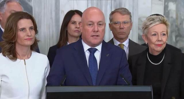 (260812) -- WELLINGTON, Aug. 12, 2026 (Xinhua) -- This screenshot from a video clip shows New Zealand Prime Minister Christopher Luxon (C, front) delivering a speech after a caucus meeting in Wellington, New Zealand, Aug. 12, 2026. New Zealand Prime Minister Christopher Luxon survived a caucus confidence vote on Wednesday and will remain leader of the governing National Party, after an hours-long caucus meeting in the capital Wellington. (Xinhua/Long Lei)
