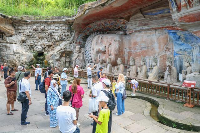 (260812) -- CHONGQING, Aug. 12, 2026 (Xinhua) -- International tourists visit the scenic area of Dazu Rock Carvings in Dazu District of southwest China's Chongqing Municipality, Aug. 11, 2026. In recent years, as China has continued to optimize its visa-free policies and other measures to facilitate travel, "China Travel" has gained global popularity, while "China Cool" has emerged as a buzzword during the summer. 
  Dazu Rock Carvings, a UNESCO World Heritage Site in Dazu District of southwest China's Chongqing Municipality, have become a popular destination for international tourists.
   According to data from the local cultural and tourism department, the site received 134,000 inbound tourist visits in 2025, up 90.07 percent year on year. From January to May this year, Dazu District recorded 68,000 inbound tourist arrivals, up 21 percent year on year. (Xinhua/Huang Wei)