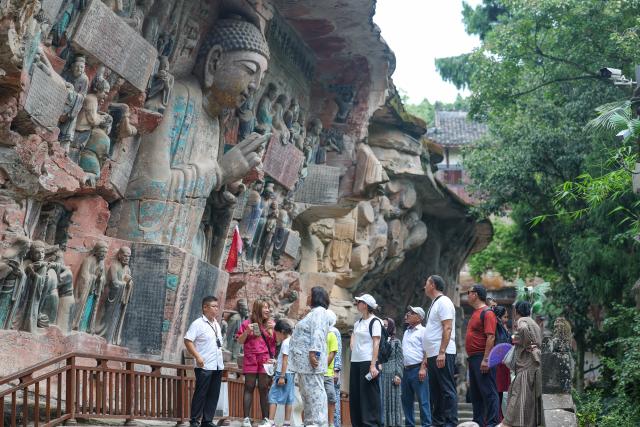 (260812) -- CHONGQING, Aug. 12, 2026 (Xinhua) -- International tourists visit the scenic area of Dazu Rock Carvings in Dazu District of southwest China's Chongqing Municipality, Aug. 11, 2026. In recent years, as China has continued to optimize its visa-free policies and other measures to facilitate travel, "China Travel" has gained global popularity, while "China Cool" has emerged as a buzzword during the summer. 
  Dazu Rock Carvings, a UNESCO World Heritage Site in Dazu District of southwest China's Chongqing Municipality, have become a popular destination for international tourists.
   According to data from the local cultural and tourism department, the site received 134,000 inbound tourist visits in 2025, up 90.07 percent year on year. From January to May this year, Dazu District recorded 68,000 inbound tourist arrivals, up 21 percent year on year. (Xinhua/Huang Wei)
