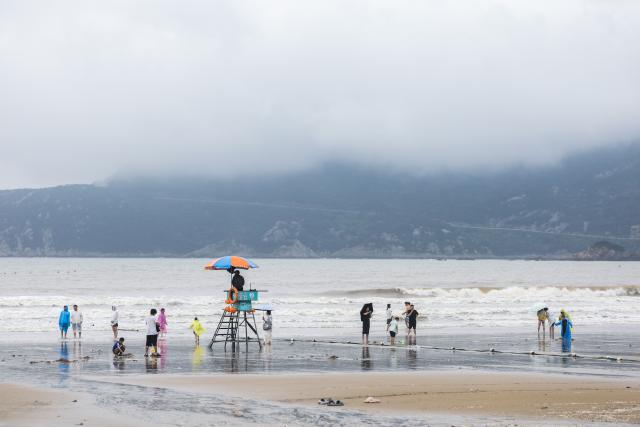 (260812) -- ZHOUSHAN, Aug. 12, 2026 (Xinhua) -- People have fun at the Nansha scenic area in Zhujiajian of Zhoushan City, east China's Zhejiang Province, Aug. 12, 2026.
  The Nansha scenic area reopened to the public on Wednesday following necessary safety checks and maintenance after Typhoon Dolphin weakened. (Xinhua/Xu Yu)