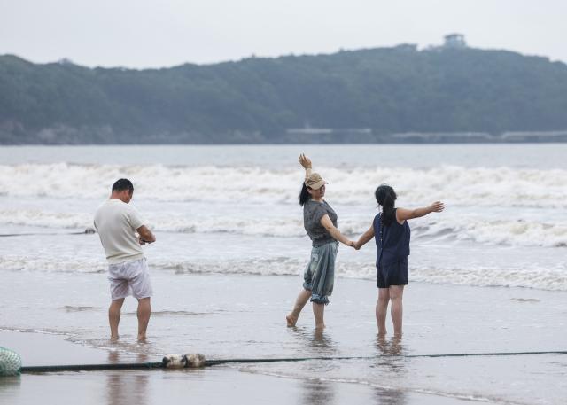 (260812) -- ZHOUSHAN, Aug. 12, 2026 (Xinhua) -- People have fun at the Nansha scenic area in Zhujiajian of Zhoushan City, east China's Zhejiang Province, Aug. 12, 2026.
  The Nansha scenic area reopened to the public on Wednesday following necessary safety checks and maintenance after Typhoon Dolphin weakened. (Xinhua/Xu Yu)