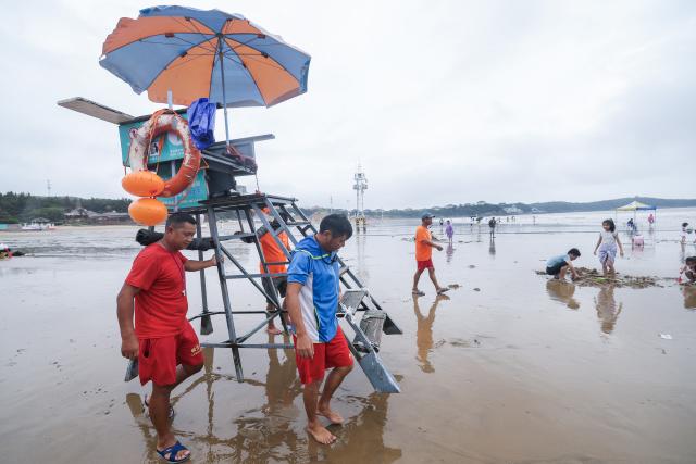 (260812) -- ZHOUSHAN, Aug. 12, 2026 (Xinhua) -- Staff members put a lifeguard stand in place at the Nansha scenic area in Zhujiajian of Zhoushan City, east China's Zhejiang Province, Aug. 12, 2026.
  The Nansha scenic area reopened to the public on Wednesday following necessary safety checks and maintenance after Typhoon Dolphin weakened. (Xinhua/Xu Yu)