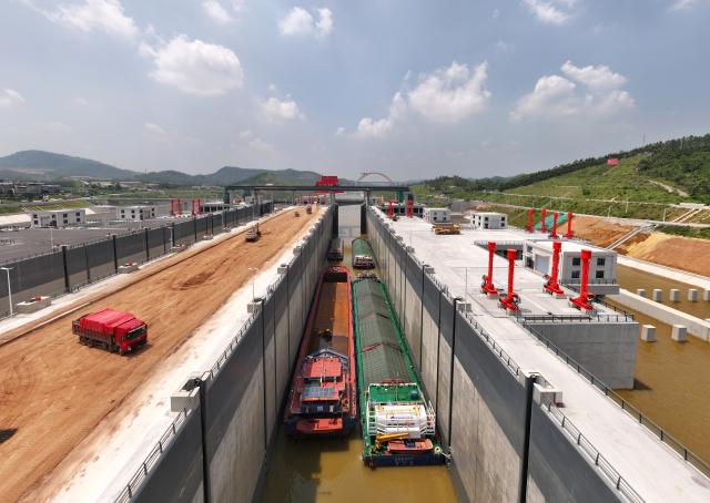 (260812) -- LINGSHAN, Aug. 12, 2026 (Xinhua) -- An aerial drone photo taken on Aug. 12, 2026 shows trial vessels preparing to drive out of a navigation lock on the Pinglu Canal in south China's Guangxi Zhuang Autonomous Region. Pinglu Canal started vessel trials on Wednesday, marking a key step toward the planned opening of this major Chinese waterway in September.
   The tests will assess navigation under both normal and adverse conditions and examine whether the canal's waterways, locks, anchorages, service areas and navigation facilities are ready for operation.
   Designed to accommodate vessels of up to 5,000 tonnes, the 134.2-km Pinglu Canal is China's first major river-to-sea canal project planned and coordinated at the national level since 1949.
   Stretching from the Pingtang River in Guangxi's Hengzhou City to the Beibu Gulf in the South China Sea, the canal is the backbone of the country's New International Land-Sea Trade Corridor, which has evolved into a strategic route linking China's inland regions with ASEAN and other global markets. (Xinhua/Zhou Hua)
