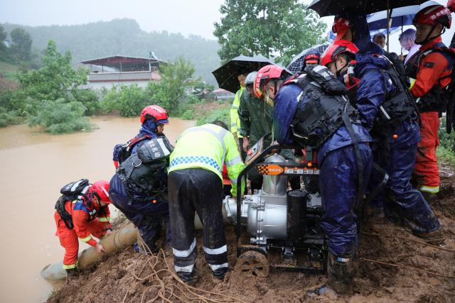 (260812) -- XIANGYANG, Aug. 12, 2026 (Xinhua) -- Rescue workers install pumping equipment to remove water and mitigate flooding risks in Siping Town, Baokang County of Xiangyang City, central China's Hubei Province, Aug. 12, 2026. Torrential rains and flooding caused by Typhoon Dolphin, the 13th typhoon of the year, have swept vast regions in eastern and central China. Local authorities are exerting all efforts to eradicate potential risks and put people's life back to normal. (Photo by Yang Dong/Xinhua)