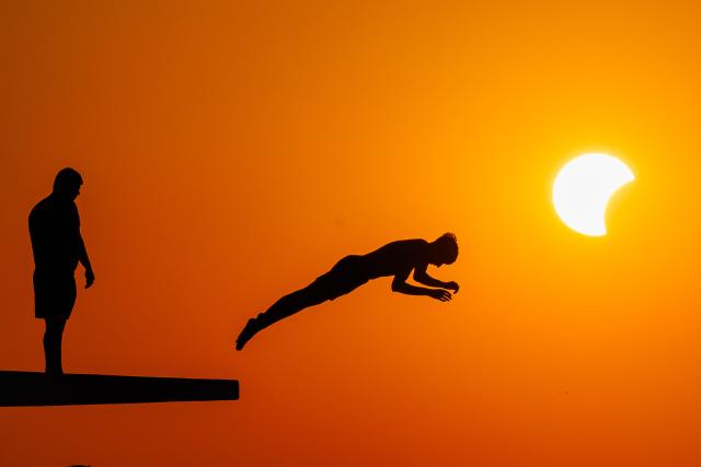 (260812) -- ZADAR, Aug. 12, 2026 (Xinhua) -- People queue to dive at Kolovare Beach as the moon partially covers the sun during a solar eclipse in Zadar, Croatia, Aug. 12, 2026. (Zvonimir Barisin/PIXSELL via Xinhua)