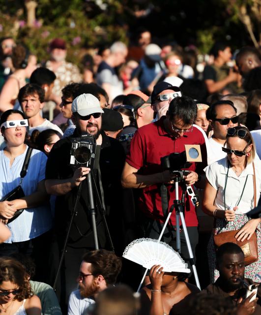 (260812) -- PARIS, Aug. 12, 2026 (Xinhua) -- People use devices to shoot a partial solar eclipse in Paris, France, Aug. 12, 2026. (Xinhua/Wu Huiwo)