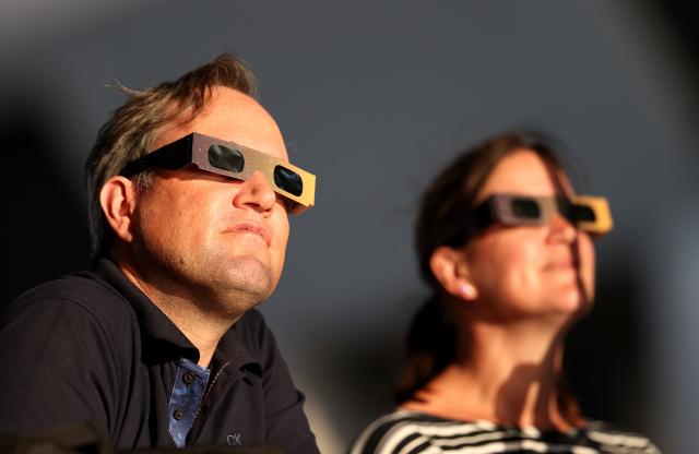 (260812) -- LONDON, Aug. 12, 2026 (Xinhua) -- People observe the partial solar eclipse in London, Britain, Aug. 12, 2026. (Xinhua/Li Ying)