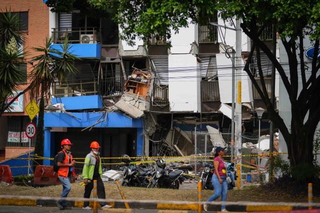 (260812) -- CALI, Aug. 12, 2026 (Xinhua) -- People walk in front of a damaged building in an earthquake in Cali, Colombia on Aug. 12, 2026. The death toll from Monday's 7.4-magnitude earthquake in western Colombia has risen to 241, with 3,771 others injured, Colombian media reported Wednesday, citing figures from the National Unit for Disaster Risk Management. (Photo by Andres Moreno/Xinhua)