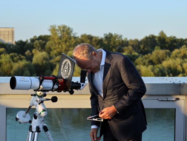 (260813) -- WARSAW, Aug. 13, 2026 (Xinhua) -- Polish Prime Minister Donald Tusk observes the partial solar eclipse at the Copernicus Science Center in Warsaw, Poland, Aug. 12, 2026. (Xinhua/Yang Yuchen)
