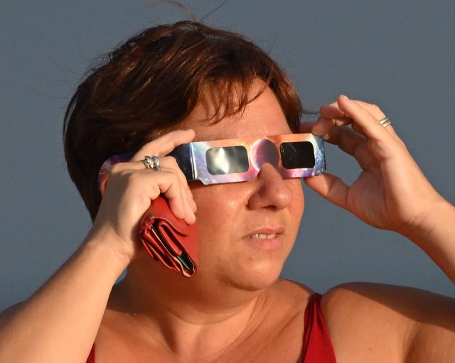 (260813) -- LADISPOLI, Aug. 13, 2026 (Xinhua) -- A woman watches a partial solar eclipse over the sea in Ladispoli, Italy, Aug. 12, 2026. (Photo by Alberto Lingria/Xinhua)