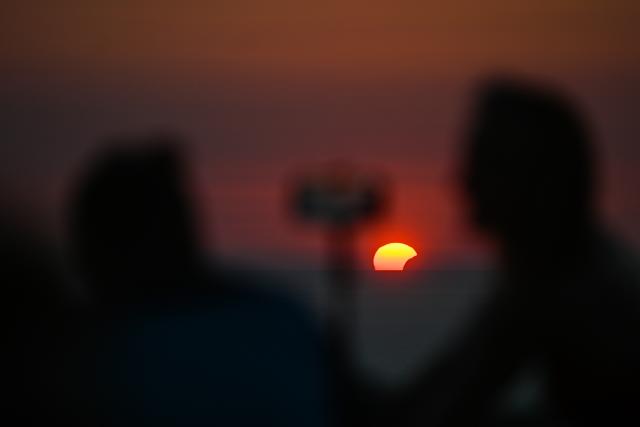 (260813) -- VALLETTA, Aug. 13, 2026 (Xinhua) -- People watch a partial solar eclipse in Dingli, Malta, on Aug. 12, 2026. (Photo by Jonathan Borg/Xinhua)