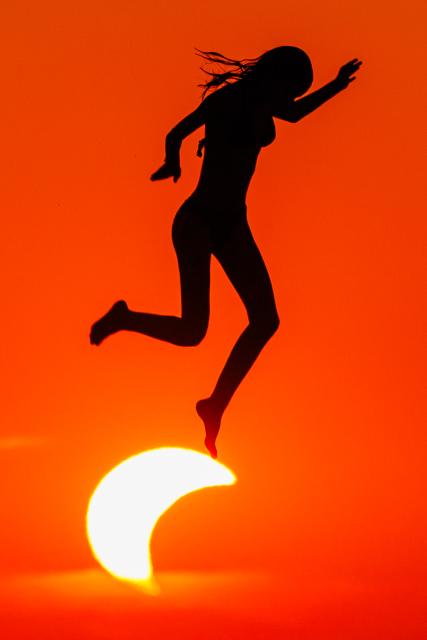 (260813) -- BEIJING, Aug. 13, 2026 (Xinhua) -- A woman jumps from the diving platform at Kolovare Beach as the moon partially covers the sun during a solar eclipse in Zadar, Croatia, Aug. 12, 2026. (Zvonimir Barisin/PIXSELL via Xinhua)