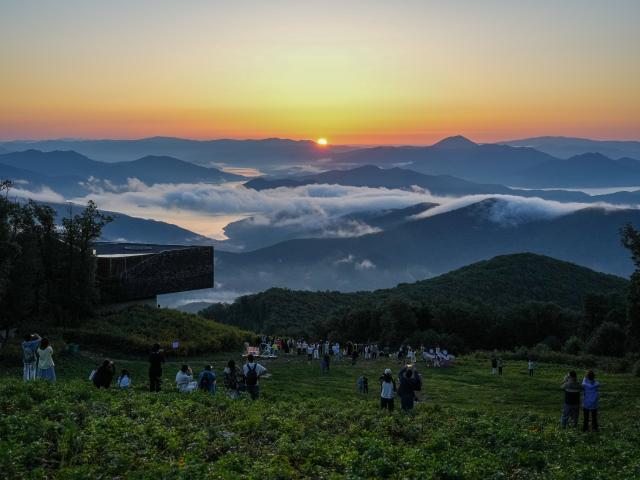 (260813) -- JILIN, Aug. 13, 2026 (Xinhua) -- Tourists watch sunrise at the Lake Songhua Resort in Jilin City, northeast China's Jilin Province, Aug. 12, 2026. The Lake Songhua Resort, located in Jilin City, is a national-level ski tourism resort. In recent years, relying on its mountain resources, the resort has extended operation in other seasons except for winter, attracting tourists with natural scenery and mountain sports. 
   Since April 25 this year, the resort has received a total of 200,000 visitors, a year-on-year growth of 20 percent. From popular destination in winter to year-round operation, the tourism potential of the resort is being fully tapped, promoting the high-quality development of the local cultural and tourism industry. (Xinhua/Zhang Nan)