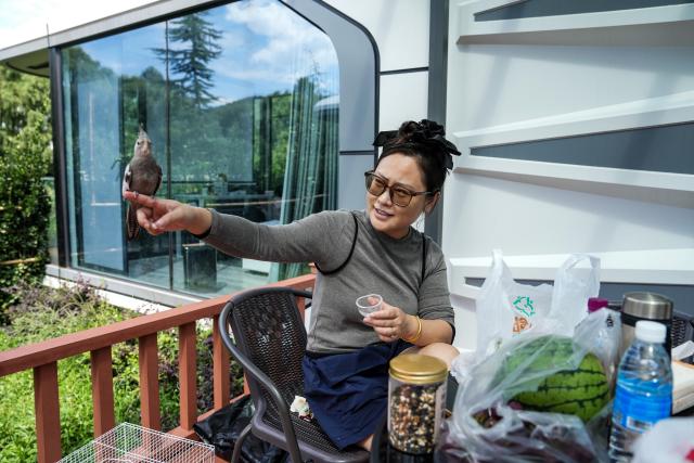 (260813) -- ZHAOTONG, Aug. 13, 2026 (Xinhua) -- A sojourner interacts with her pet parrot at a hot spring hotel in Xunlong Village of Sayu Town, Zhaoyang District in Zhaotong City, southwest China's Yunnan Province, Aug. 13, 2026. In recent years, Zhaoyang District in Zhaotong City has leveraged its cool and pleasant climate to boost the in-depth sojourn tourism experience as a summer retreat.
   The local government has introduced special support policies for summer retreat tourism, optimizing services including dining, lodging, transportation, sightseeing, shopping, and entertainment. (Xinhua/Chen Xinbo)