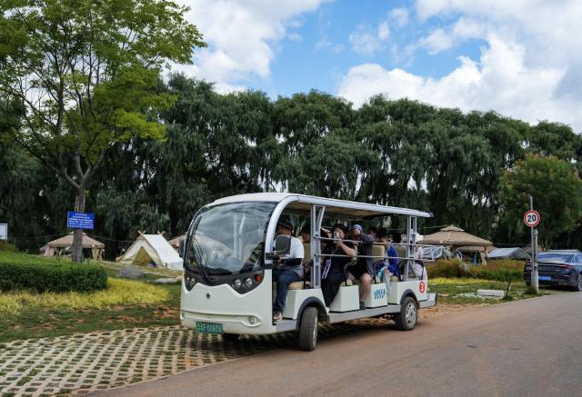 (260813) -- ZHAOTONG, Aug. 13, 2026 (Xinhua) -- Tourists take a sightseeing vehicle in Xunlong Village, Sayu Town, Zhaoyang District, Zhaotong City, southwest China's Yunnan Province, Aug. 13, 2026. In recent years, Zhaoyang District in Zhaotong City has leveraged its cool and pleasant climate to boost the in-depth sojourn tourism experience as a summer retreat.
   The local government has introduced special support policies for summer retreat tourism, optimizing services including dining, lodging, transportation, sightseeing, shopping, and entertainment. (Xinhua/Chen Xinbo)