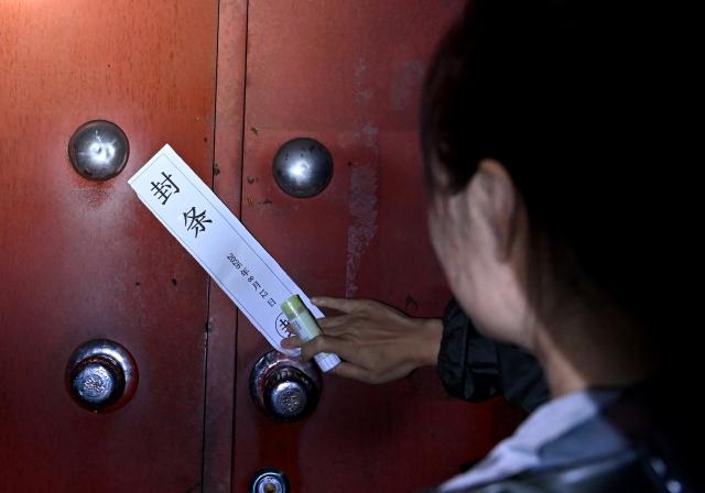 (260813) -- LUOHE, Aug. 13, 2026 (Xinhua) -- A staff member affixes a seal on the door of an evacuated household in Beiwudu Town of Wuyang County, Luohe, central China's Henan Province, Aug. 13, 2026. Thousands of people have been evacuated in central China's Henan Province after days of torrential rain swelled rivers and triggered a levee breach, local authorities said Thursday.
  In Luohe City, more than 4,500 people from 10 villages were evacuated amid rising concerns over potential river flooding.
  From Monday afternoon to Wednesday afternoon, the city recorded an average rainfall of 270.1 millimeters, with a peak of 434.2 millimeters, prompting authorities to activate the highest-level flood control emergency response. (Xinhua/Hao Yuan)