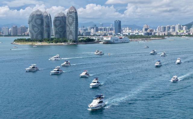 (260813) -- HAIKOU, Aug. 13, 2026 (Xinhua) -- An aerial drone photo taken on Aug. 4, 2026 shows tourists taking yachts in Sanya, south China's Hainan Province. Hainan is stepping up with efforts to build a world-class destination for international tourism and consumption as a key component of the Hainan Free Trade Port, and to probe for a new path towards high-quality development in its tourism-led consumer economy with distinctive local characteristics. 
   Hainan is projected to annually receive 154 million counts of domestic and international visits by 2030, along with tourism-related revenue of 363 billion yuan (about 53.83 billion U.S. dollars). (Xinhua/Zhao Yingquan)