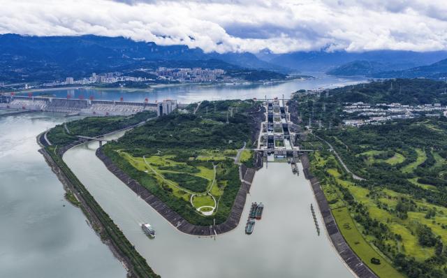 (260813) -- ZIGUI, Aug. 13, 2026 (Xinhua) -- An aerial drone photo taken on Aug. 13, 2026 shows vessels passing through the ship locks (R) and the ship lift (L) of the Three Gorges in Yichang City, central China's Hubei Province. The throughput of the Three Gorges Water Control Hub from the beginning of this year to 00:40 on Aug. 13 was estimated to reach 100 million tons. The ship locks operated 5,863 times to let through 21,562 vessels with a total throughput of 97.276 million tons; while the ship lift operated 2,557 times to move 2,590 vessels with a total of 446,000 passengers. (Photo by Zheng Jiayu/Xinhua)