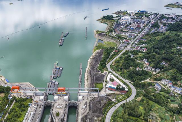 (260813) -- ZIGUI, Aug. 13, 2026 (Xinhua) -- An aerial drone photo taken on Aug. 13, 2026 shows vessels preparing to go through the ship locks of the Three Gorges in Yichang City, central China's Hubei Province. The throughput of the Three Gorges Water Control Hub from the beginning of this year to 00:40 on Aug. 13 was estimated to reach 100 million tons. The ship locks operated 5,863 times to let through 21,562 vessels with a total throughput of 97.276 million tons; while the ship lift operated 2,557 times to move 2,590 vessels with a total of 446,000 passengers. (Photo by Zheng Jiayu/Xinhua)