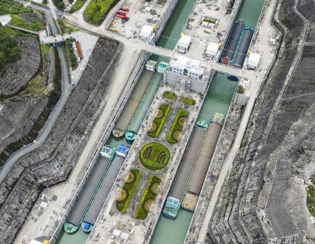 (260813) -- ZIGUI, Aug. 13, 2026 (Xinhua) -- An aerial drone photo taken on Aug. 13, 2026 shows vessels passing through the ship locks of the Three Gorges in Yichang City, central China's Hubei Province. The throughput of the Three Gorges Water Control Hub from the beginning of this year to 00:40 on Aug. 13 was estimated to reach 100 million tons. The ship locks operated 5,863 times to let through 21,562 vessels with a total throughput of 97.276 million tons; while the ship lift operated 2,557 times to move 2,590 vessels with a total of 446,000 passengers. (Photo by Zheng Jiayu/Xinhua)