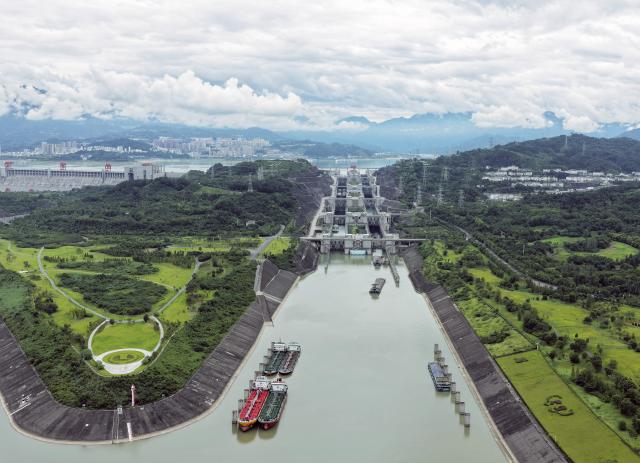 (260813) -- ZIGUI, Aug. 13, 2026 (Xinhua) -- An aerial drone photo taken on Aug. 13, 2026 shows vessels passing through the ship locks of the Three Gorges in Yichang City, central China's Hubei Province. The throughput of the Three Gorges Water Control Hub from the beginning of this year to 00:40 on Aug. 13 was estimated to reach 100 million tons. The ship locks operated 5,863 times to let through 21,562 vessels with a total throughput of 97.276 million tons; while the ship lift operated 2,557 times to move 2,590 vessels with a total of 446,000 passengers. (Photo by Wang Gang/Xinhua)