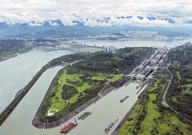 (260813) -- ZIGUI, Aug. 13, 2026 (Xinhua) -- An aerial drone photo taken on Aug. 13, 2026 shows vessels passing through the ship locks of the Three Gorges in Yichang City, central China's Hubei Province. The throughput of the Three Gorges Water Control Hub from the beginning of this year to 00:40 on Aug. 13 was estimated to reach 100 million tons. The ship locks operated 5,863 times to let through 21,562 vessels with a total throughput of 97.276 million tons; while the ship lift operated 2,557 times to move 2,590 vessels with a total of 446,000 passengers. (Photo by Wang Gang/Xinhua)