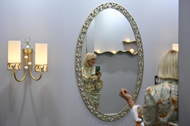 (260813) -- MOSCOW, Aug. 13, 2026 (Xinhua) -- A woman takes photos of interior design works displayed at the Manege Central Exhibition Hall in Moscow, Russia, on Aug. 13, 2026. The 8th Moscow Interior and Design Week kicked off at the Manege Central Exhibition Hall here on Thursday. Under the theme "Infinite Colours," the event draws participation from about 1,300 Russian and foreign brands and will run until Aug. 16. (Photo by Alexander Zemlianichenko Jr/Xinhua)
