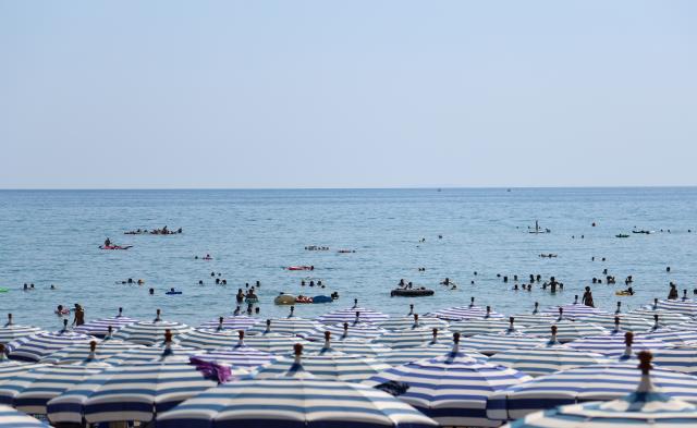 (260814) -- BEIJING, Aug. 14, 2026 (Xinhua) -- Tourists enjoy themselves on a beach during a heatwave in Sperlonga, Italy, Aug. 12, 2026. (Xinhua/Wang Kaiyan)
