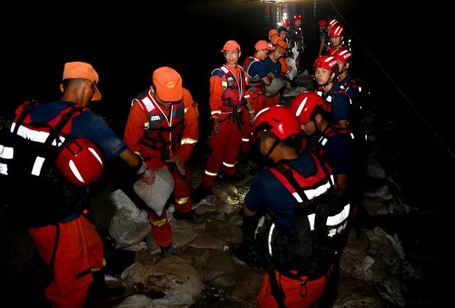 (260814) -- JIAXIAN, Aug. 14, 2026 (Xinhua) -- Rescuers work at the site of a levee breach along the Beiru River in Jiaxian County, central China's Henan Province, Aug. 13, 2026.
  A levee along the Beiru River in Jiaxian County gave way on Wednesday night, following extreme rainfall and large-volume discharges from upstream reservoirs.
  As of Thursday, a total of 2,182 people had been evacuated to safety, with no casualties reported so far. Efforts to contain the levee breach are underway. (Xinhua/Hao Yuan)