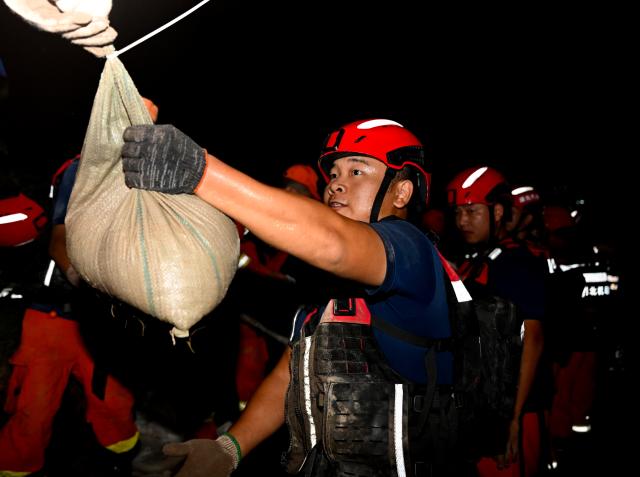 (260814) -- JIAXIAN, Aug. 14, 2026 (Xinhua) -- Rescuers work at the site of a levee breach along the Beiru River in Jiaxian County, central China's Henan Province, Aug. 13, 2026.
  A levee along the Beiru River in Jiaxian County gave way on Wednesday night, following extreme rainfall and large-volume discharges from upstream reservoirs.
  As of Thursday, a total of 2,182 people had been evacuated to safety, with no casualties reported so far. Efforts to contain the levee breach are underway. (Xinhua/Hao Yuan)