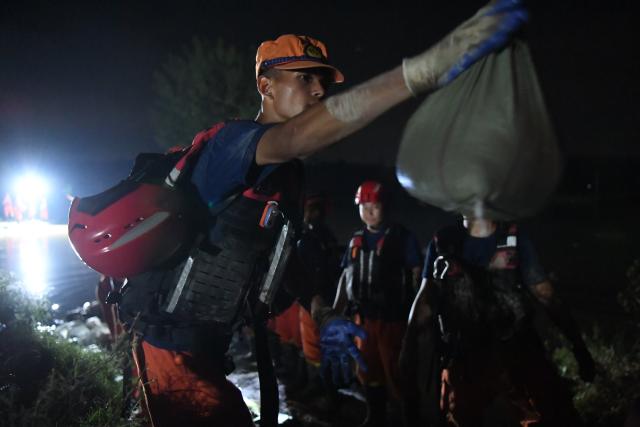 (260814) -- JIAXIAN, Aug. 14, 2026 (Xinhua) -- Rescuers work at the site of a levee breach along the Beiru River in Jiaxian County, central China's Henan Province, Aug. 13, 2026.
  A levee along the Beiru River in Jiaxian County gave way on Wednesday night, following extreme rainfall and large-volume discharges from upstream reservoirs.
  As of Thursday, a total of 2,182 people had been evacuated to safety, with no casualties reported so far. Efforts to contain the levee breach are underway. (Photo by Kong Weijia/Xinhua)
