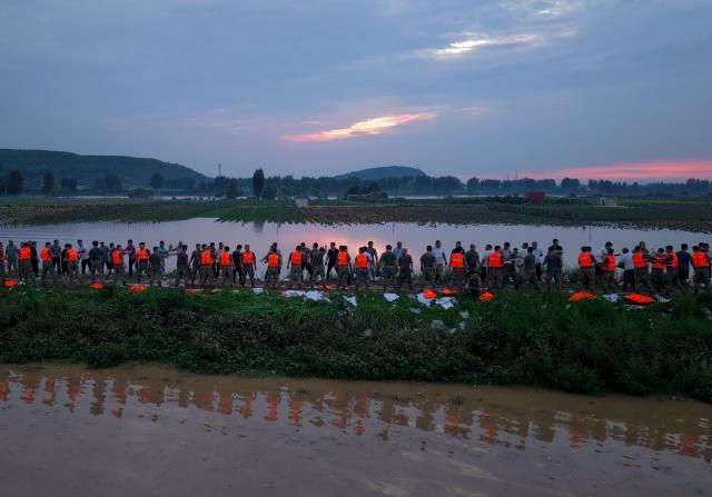 (260814) -- JIAXIAN, Aug. 14, 2026 (Xinhua) -- An aerial drone photo shows repair work underway at the site of a levee breach along the Beiru River in Jiaxian County, central China's Henan Province, Aug. 13, 2026.
  A levee along the Beiru River in Jiaxian County gave way on Wednesday night, following extreme rainfall and large-volume discharges from upstream reservoirs.
  As of Thursday, a total of 2,182 people had been evacuated to safety, with no casualties reported so far. Efforts to contain the levee breach are underway. (Xinhua/Hao Yuan)