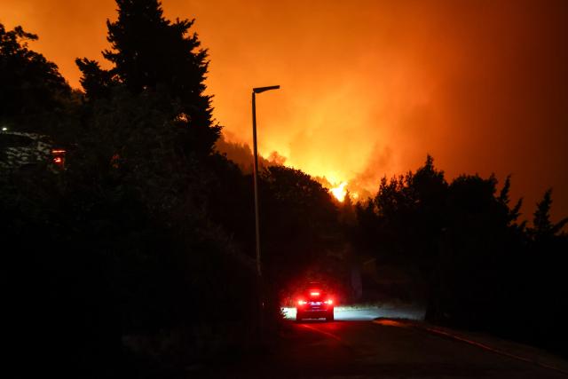 (260814) -- OMIS, Aug. 14, 2026 (Xinhua) -- A vehicle runs as a massive wildfire rages at the coastal town of Omis, Croatia, on Aug. 13, 2026.
  At least 1,000 residents and tourists have been evacuated after a massive wildfire spread into the coastal town of Omis in southern Croatia, local media reported early Friday. (Zvonimir Barisin/PIXSELL via Xinhua)