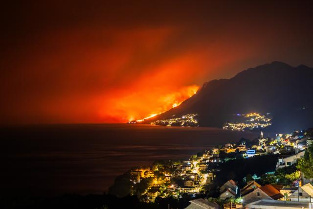 (260814) -- OMIS, Aug. 14, 2026 (Xinhua) -- This photo taken on Aug. 13, 2026 shows a massive wildfire near the coastal town of Omis, Croatia.
  At least 1,000 residents and tourists have been evacuated after a massive wildfire spread into the coastal town of Omis in southern Croatia, local media reported early Friday. (Zvonimir Barisin/PIXSELL via Xinhua)