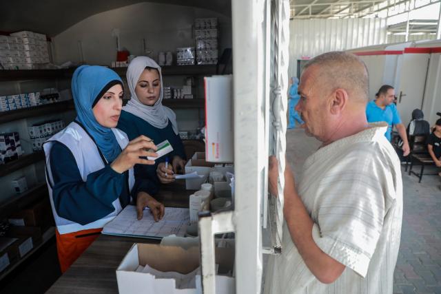 (260814) -- GAZA, Aug. 14, 2026 (Xinhua) -- A Palestinian man gets medicine at a field hospital run by the Palestinian Red Crescent Society in central Gaza City on Aug. 11, 2026. TO GO WITH "Feature: Amid sewage swamps and dilapidated tents, displaced Gazans besieged by skin diseases" (Photo by Rizek Abdeljawad/Xinhua)