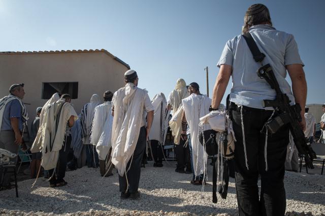 (260814) -- JERUSALEM, Aug. 14, 2026 (Xinhua) -- Jewish settlers carrying rifles attend a ritual for the re-establishment of the Ganim settlement in the West Bank on Aug. 13, 2026.
  Four settlements in the West Bank, including Ganim, were evacuated in 2005 as part of Israel's "Disengagement Plan". The Ganim settlement has now been re-established, 21 years after its evacuation. (Xinhua/Chen Junqing)