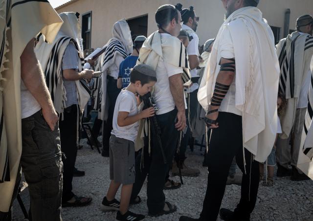 (260814) -- JERUSALEM, Aug. 14, 2026 (Xinhua) -- Jewish settlers carrying rifles attend a ritual for the re-establishment of the Ganim settlement in the West Bank on Aug. 13, 2026.
  Four settlements in the West Bank, including Ganim, were evacuated in 2005 as part of Israel's "Disengagement Plan". The Ganim settlement has now been re-established, 21 years after its evacuation. (Xinhua/Chen Junqing)