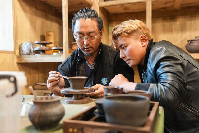 (260814) -- ABA, Aug. 14, 2026 (Xinhua) -- A man learns Tibetan pottery making from an instructor at a studio in Aba County, Aba Tibetan and Qiang Autonomous Prefecture, southwest China's Sichuan Province, Aug. 12, 2026. In recent years, Aba Tibetan and Qiang Autonomous Prefecture has leveraged its rich plateau resources to promote the development of agriculture and tourism, injecting new impetus into rural revitalization here. (Xinhua/Wang Xi)