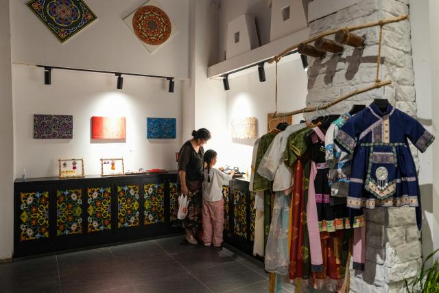 (260814) -- ABA, Aug. 14, 2026 (Xinhua) -- Tourists select cultural and creative products in Wenchuan County, Aba Tibetan and Qiang Autonomous Prefecture, southwest China's Sichuan Province, Aug. 10, 2026. In recent years, Aba Tibetan and Qiang Autonomous Prefecture has leveraged its rich plateau resources to promote the development of agriculture and tourism, injecting new impetus into rural revitalization here. (Xinhua/Wang Xi)