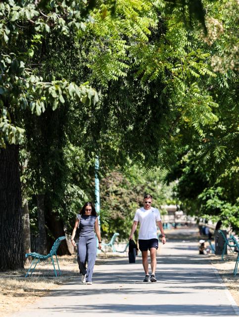 (260814) -- PARIS, Aug. 14, 2026 (Xinhua) -- People walk in a park near the Seine River during a heatwave in Paris, France, Aug. 14, 2026. (Xinhua/Wu Huiwo)