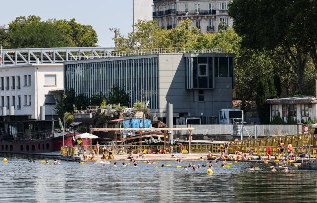 (260814) -- PARIS, Aug. 14, 2026 (Xinhua) -- People swim in the Seine River during a heatwave in Paris, France, Aug. 14, 2026. (Xinhua/Wu Huiwo)