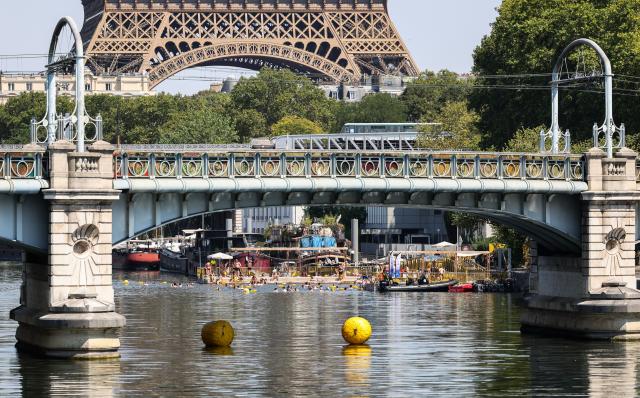 (260814) -- PARIS, Aug. 14, 2026 (Xinhua) -- People swim in the Seine River during a heatwave in Paris, France, Aug. 14, 2026. (Xinhua/Wu Huiwo)